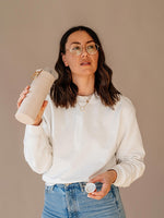 Girl drinking from EQUA glass water bottle Beige.